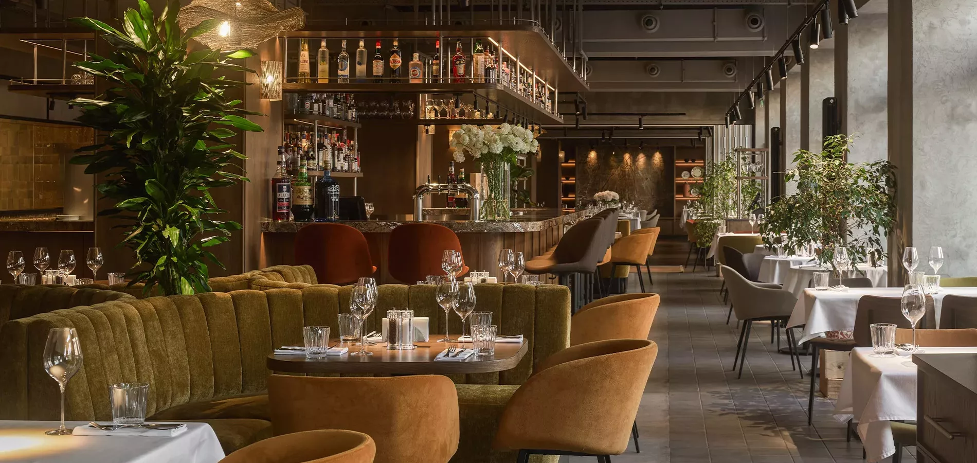 KIRA: spacious dining room, plants, and soft seating. Photo: KIRA restaurant